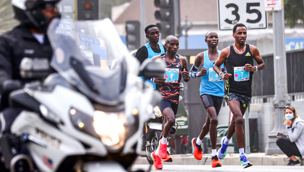 In this file photo, John Korir of Kenya (2nd R) runs along Hollywood Boulevard on his way to winning the pandemic-delayed 36th annual Los Angeles Marathon in Los Angeles on Nov. 7, 2021. (Mario Tama/Getty Images)