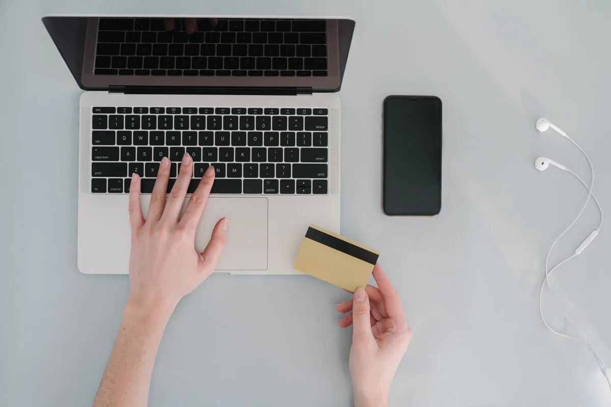 Stock photo of a person transacting a bankcard online using a laptop. (Mikhail Nilov/Pexels)