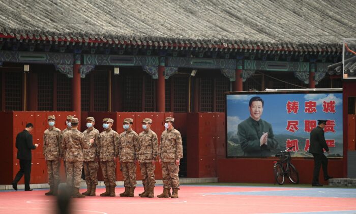 3月，在北京附近的人民大会堂举行全国人民代表大会（NPC）闭幕会议时，安全人员在中国国家主席习近平（右）像附近的紫禁城入口处站岗2022 年 11 月 11 日。（Noel Celis/法新社通过 Getty Images）