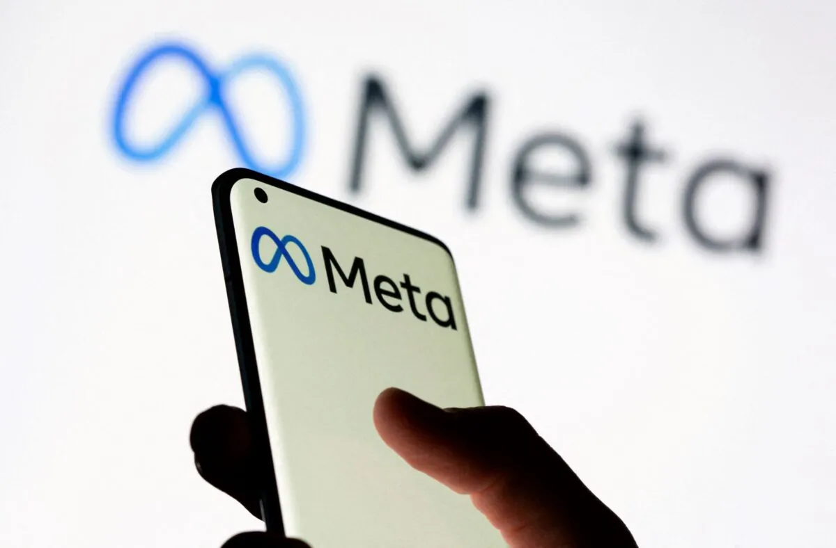 A woman holds a smartphone with the Meta logo in front of a displayed Facebook's new rebrand logo in this illustration picture taken on Oct. 28, 2021. (Dado Ruvic/Illustration/Reuters)