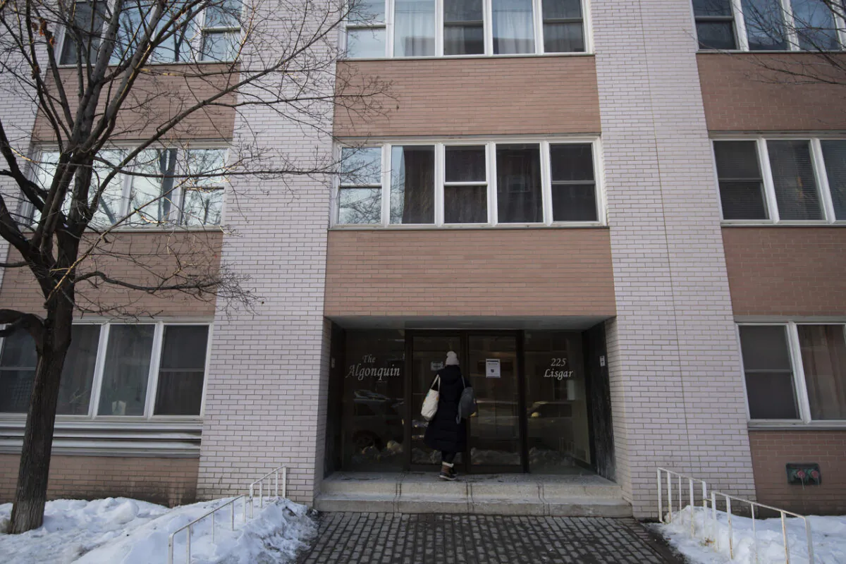 A person enters an apartment on Lisgar Street, where police said two men attempted to start a fire in the building’s lobby, in Ottawa on Feb. 7, 2022. (The Canadian Press/Justin Tang)