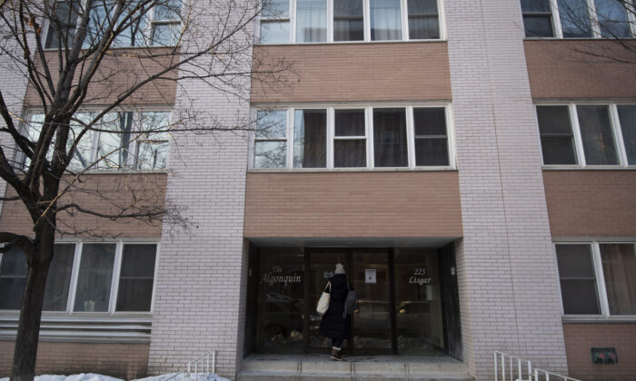 A person enters an apartment on Lisgar Street, where police said two men attempted to start a fire in the building’s lobby, in Ottawa on Feb. 7, 2022. (The Canadian Press/Justin Tang)