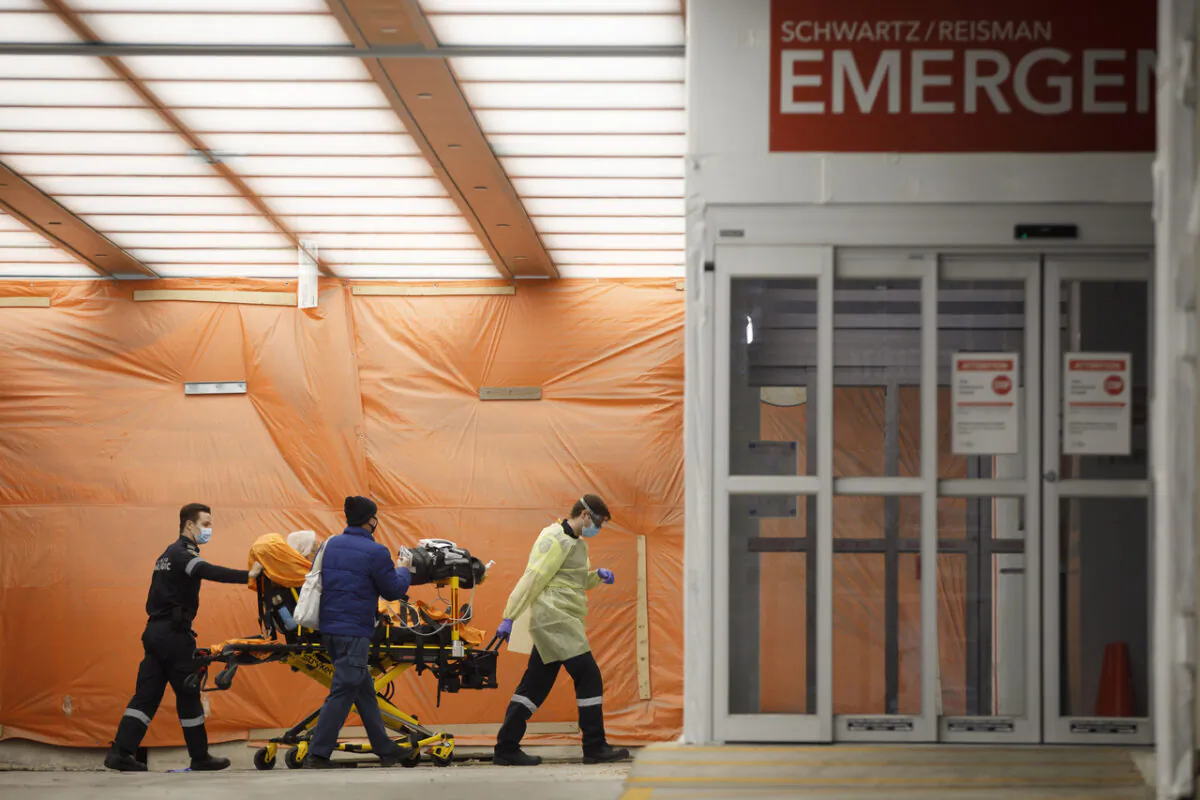 Paramedics wheel a patient into the emergency department at Mount Sinai Hospital in Toronto on Jan. 13, 2021. (The Canadian Prss/Cole Burston)