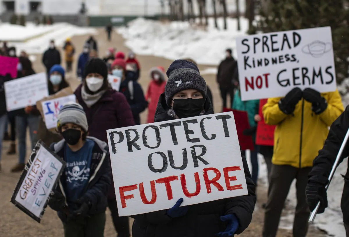 Protesters show support for students, teachers, and health-care professionals at the Alberta legislature after students walked out of their classrooms to protest the government's decision to lift a mask mandate in schools, in Edmonton on Feb. 14, 2021. (The Canadian Press/Jason Franson)
