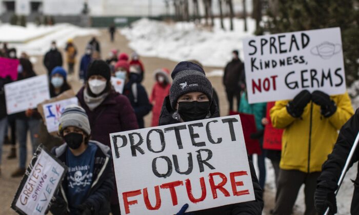 Protesters show support for students, teachers, and health-care professionals at the Alberta legislature after students walked out of their classrooms to protest the government's decision to lift a mask mandate in schools, in Edmonton on Feb. 14, 2021. (The Canadian Press/Jason Franson)
