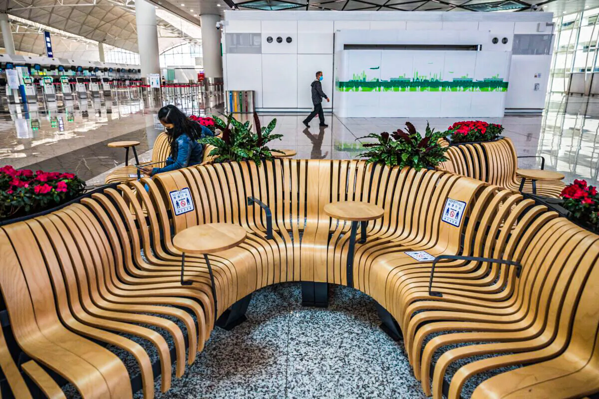 A woman uses her phone at the Hong Kong International Airport in Hong Kong on March 21, 2022. (DALE DE LA REY/AFP via Getty Images)