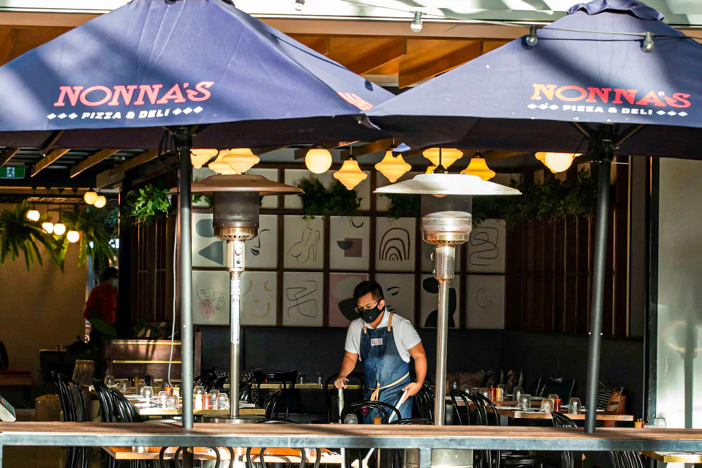 A worker cleans while wearing a mask at a restaurant at Southbank, Brisbane in Australia, on June 29, 2021. (Jono Searle/Getty Images)