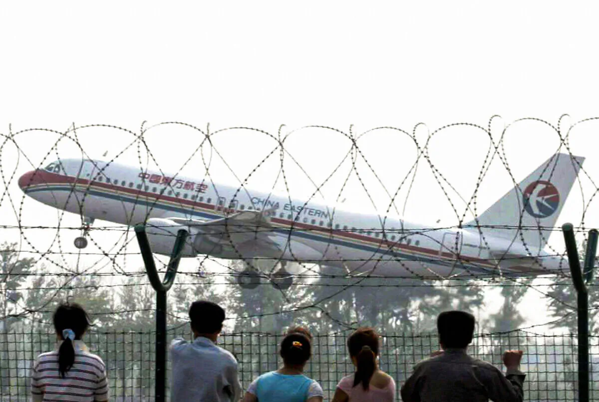 On-lookers watch a China Eastern airliner taking off from the Beijing International airport on May 11, 2005. (STR/AFP via Getty Images)