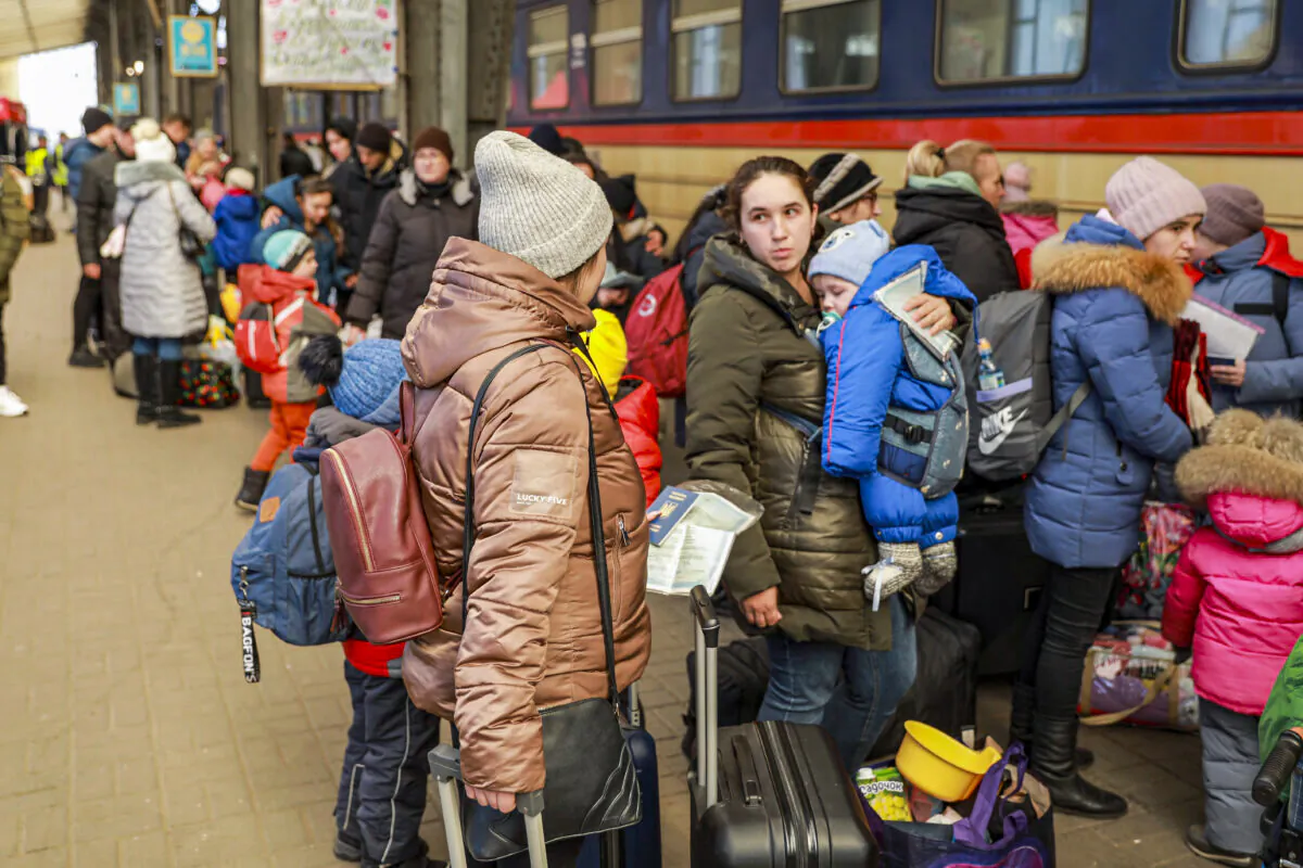 Ukrainian refugees prepare to board a train to Poland at the train station in Lviv, Ukraine, on March 18, 2022. (Charlotte Cuthbertson/The Epoch Times)