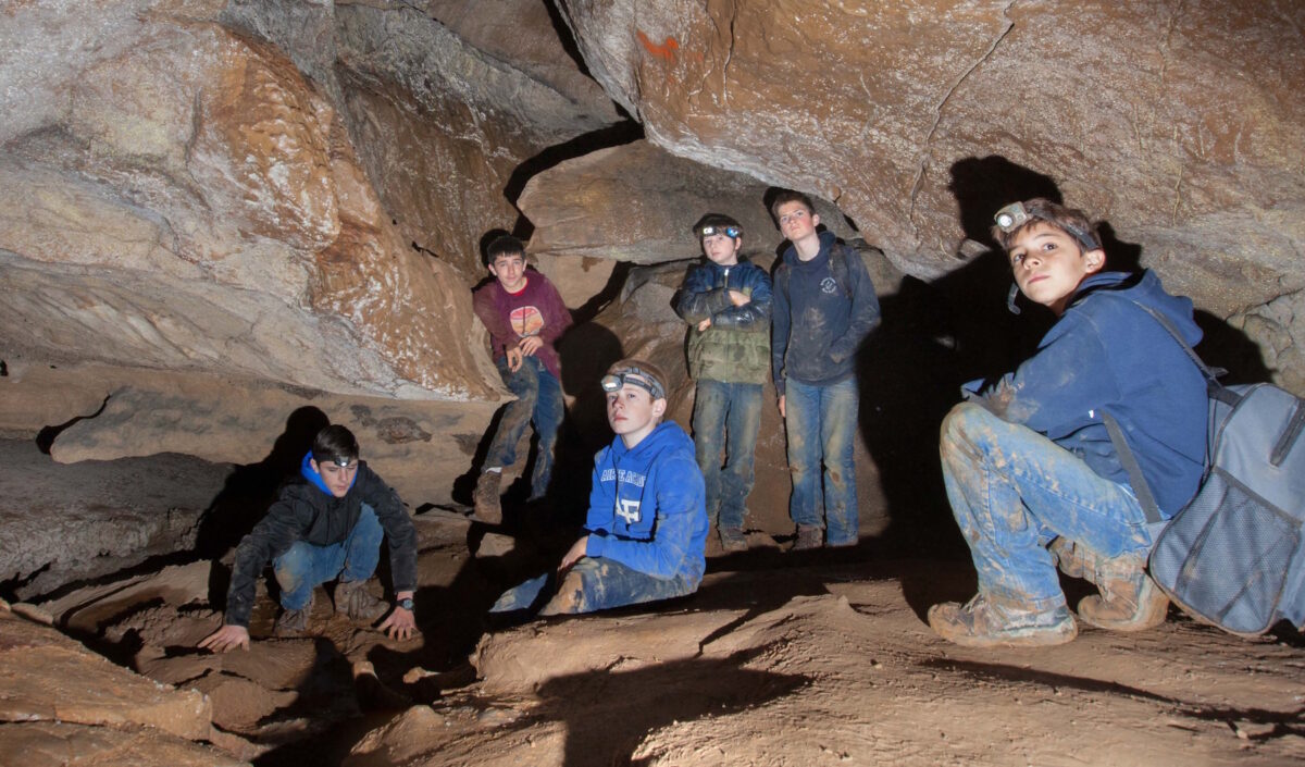 Boys from the Buffalo Creek Boys School venture into a local limestone cave (the Taylors had explored the cave beforehand with an eye to safety). “Getting dirty, climbing and adventuring through the unknown is always exciting to boys,” Rebecca Taylor said. (Courtesy of BCBS)