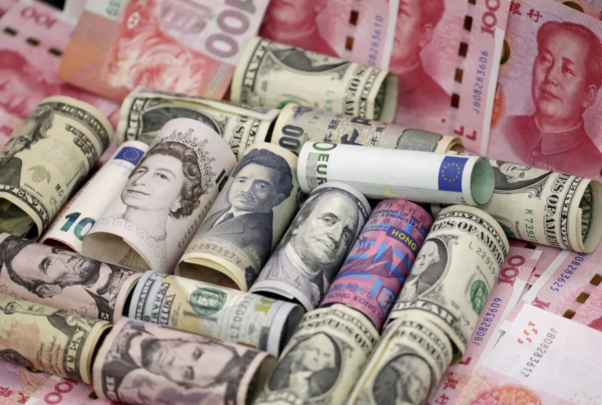 A $100 bill sits among paper notes of the British pound sterling, Japanese yen, and other currencies in this photo illustration in Tokyo on Feb. 28, 2013. (Shohei Miyano/Reuters)