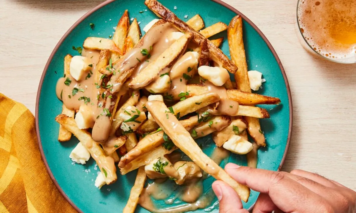Poutine is a Canadian classic made of fried potatoes covered in cheddar cheese curds and rich brown gravy. (Christopher Testani/TNS)
