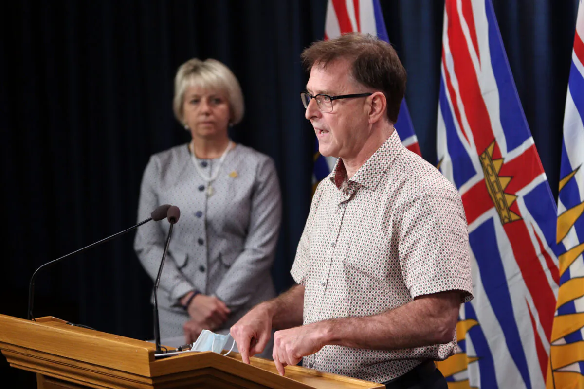 Provincial Health Officer Dr. Bonnie Henry looks on as Health Minister Adrian Dix speaks about the COVID-19 vaccine card during a press conference at provincial legislature in Victoria, on Aug. 23, 2021. (The Canadian Press/Chad Hipolito)
