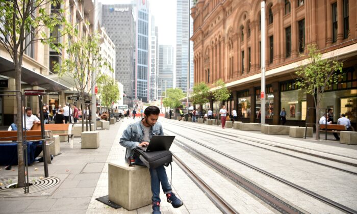 This photo shows a man using a laptop computer on a street in the central business district of Sydney, Australia, on Nov. 5, 2018. (Peter Parks/AFP via Getty Images)