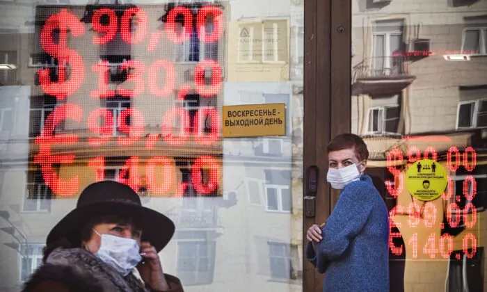 People walk past a currency exchange office in central Moscow on Feb. 28, 2022. (Alexander Nemenov/AFP via Getty Images)