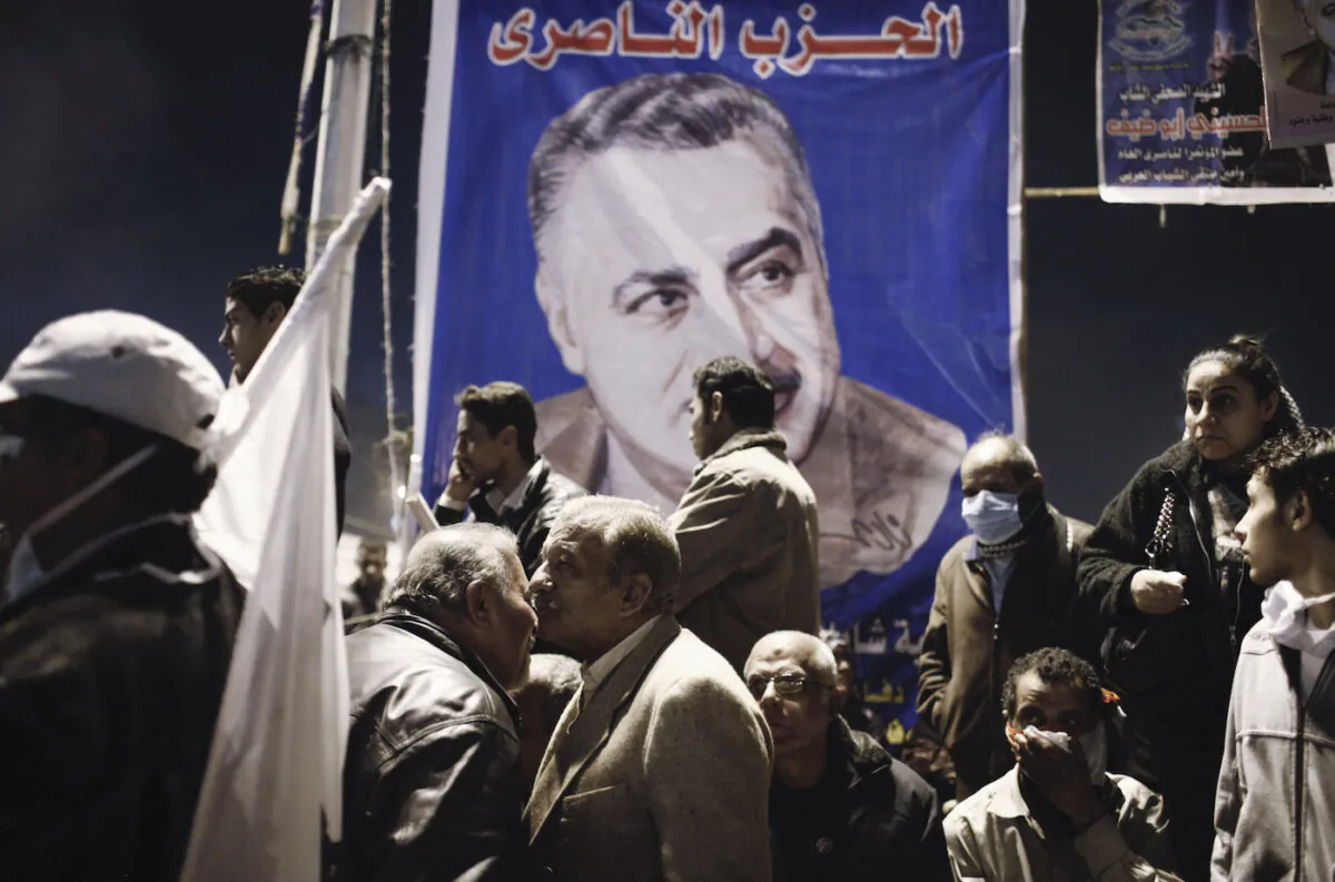 Protesters stand below a poster of former Egyptian leader Gamal Abdel Nasser during a demonstration in Tahrir Square, Cairo, Egypt, on Jan. 25, 2013. (Ed Giles/Getty Images).