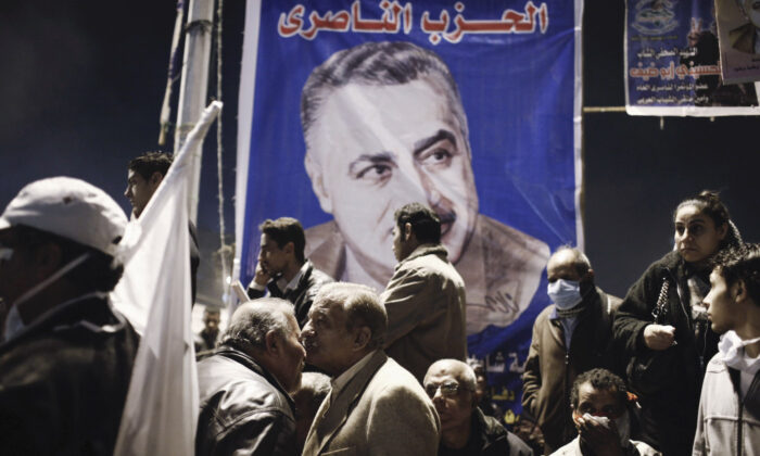 Protesters stand below a poster of former Egyptian leader Gamal Abdel Nasser during a demonstration in Tahrir Square, Cairo, Egypt, on Jan. 25, 2013. (Ed Giles/Getty Images).