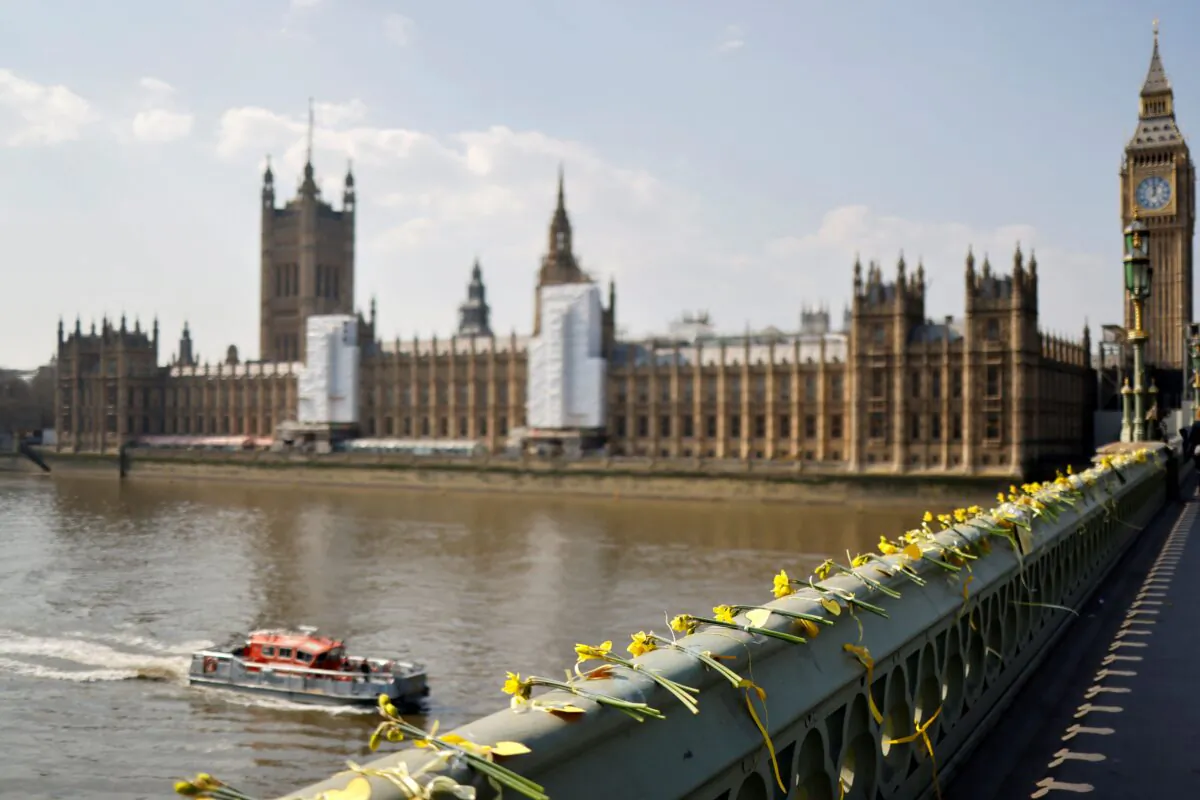 As Britain held a minute's silence to remember the victims of the COVID-19 pandemic, on the second anniversary of the country's first lockdown, flowers are laid at Westminster Bridge in London on March 23, 2022.  (Tolga Akmen /AFP via Getty Images)
