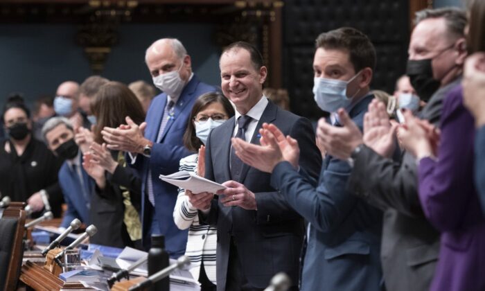Quebec Finance Minister Eric Girard, centre is applauded by members of the government as he presents the government's budget, March 22, 2022 at the legislature in Quebec City. (The Canadian Press/Jacques Boissinot)