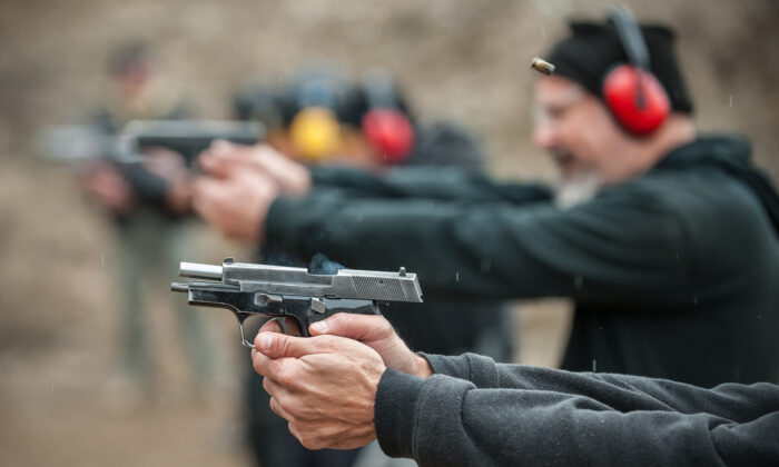 Civilians firing guns at a shooting range. (guruXOX/Adobe Stock)
