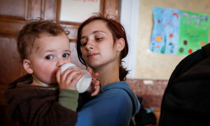 Alina Kaconskaya with her baby Denis at the Lviv train station in Lviv, Ukraine, on March 24, 2022. (Charlotte Cuthbertson/The Epoch Times)