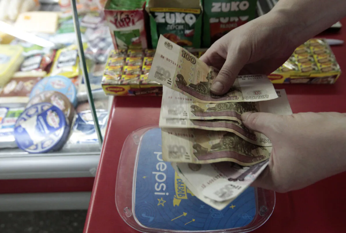 A shop assistant demonstrates Russian rouble banknotes at a grocery in Stavropol, southern Russia, Jan. 21, 2016. (Eduard Korniyenko/Reuters)