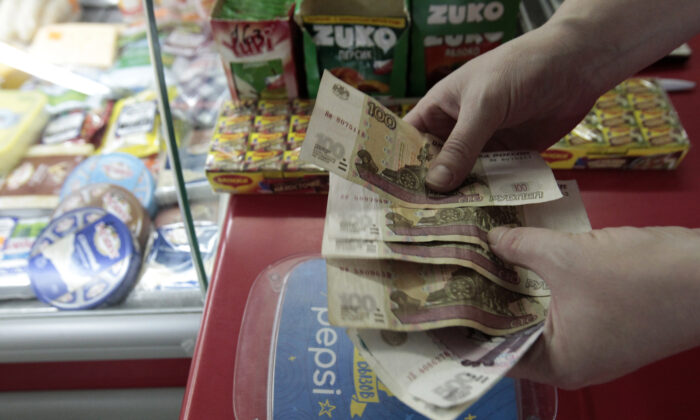 A shop assistant demonstrates Russian rouble banknotes at a grocery in Stavropol, southern Russia, Jan. 21, 2016. (Eduard Korniyenko/Reuters)
