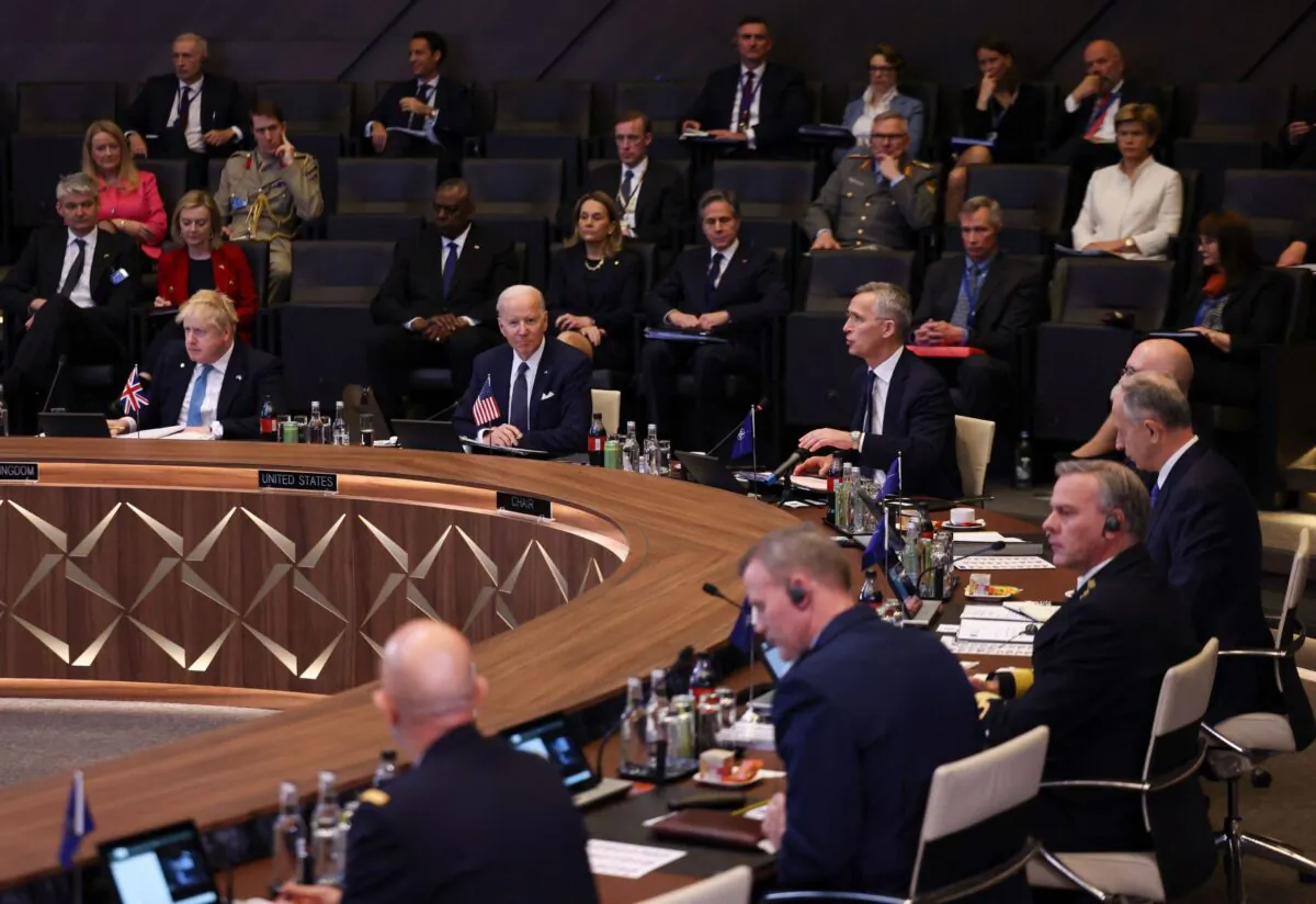 British Prime Minister Boris Johnson (L) and President Joe Biden (C) listen as NATO Secretary General Jens Stoltenberg (C/R) addresses a North Atlantic Council meeting during an extrordinary summit at NATO Headquarters in Brussels on March 24, 2022. (Evelyn Hockstein/Pool/AFP via Getty Images)