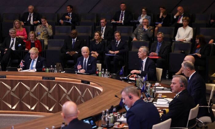 British Prime Minister Boris Johnson (L) and President Joe Biden (C) listen as NATO Secretary General Jens Stoltenberg (C/R) addresses a North Atlantic Council meeting during an extrordinary summit at NATO Headquarters in Brussels on March 24, 2022. (Evelyn Hockstein/Pool/AFP via Getty Images)