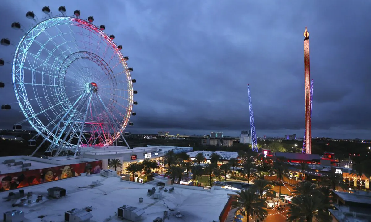 ICON Park attractions, The Wheel, left, Orlando SlingShot, middle, and Orlando FreeFall, right, are shown in Orlando, Fla. on March 24, 2022. (Stephen M. Dowell/Orlando Sentinel via AP)