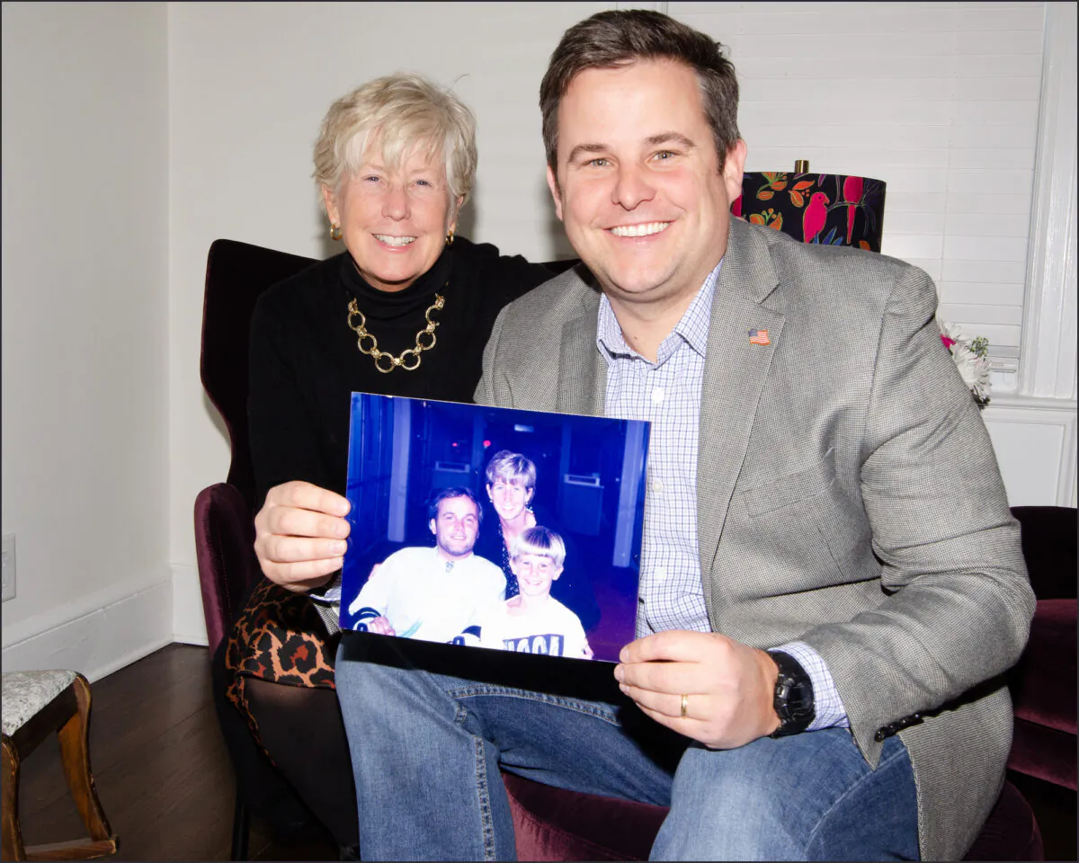 Lt. Conor McDonald of the NYPD, son of paralyzed and deceased officer Steven McDonald, and his mother Patti Ann McDonald, with a family photo of the three of them. (Dave Paone/The Epoch Times)