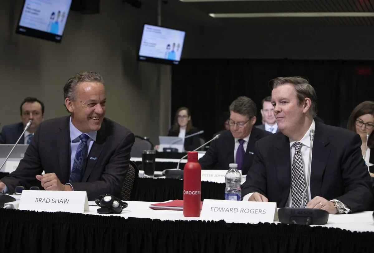 Edward Rogers, right, Chairman of Rogers Communications, and Brad Shaw, Chairman and CEO of Shaw Communications, chat before the start of the CRTC hearing in Gatineau, Quebec, on Nov. 22, 2021. (The Canadian Press/Fred Chartrand)
