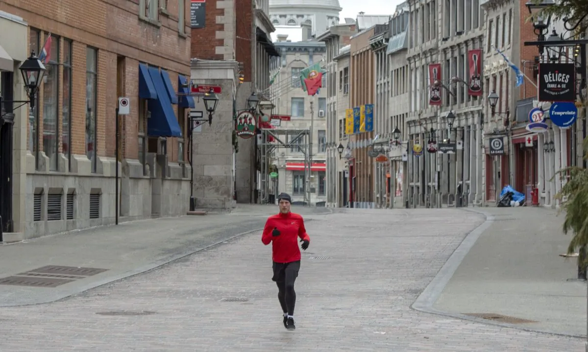 A runner makes his way through the empty streets of Old Montreal on April 1, 2020. (The Canadian Press/Ryan Remiorz)