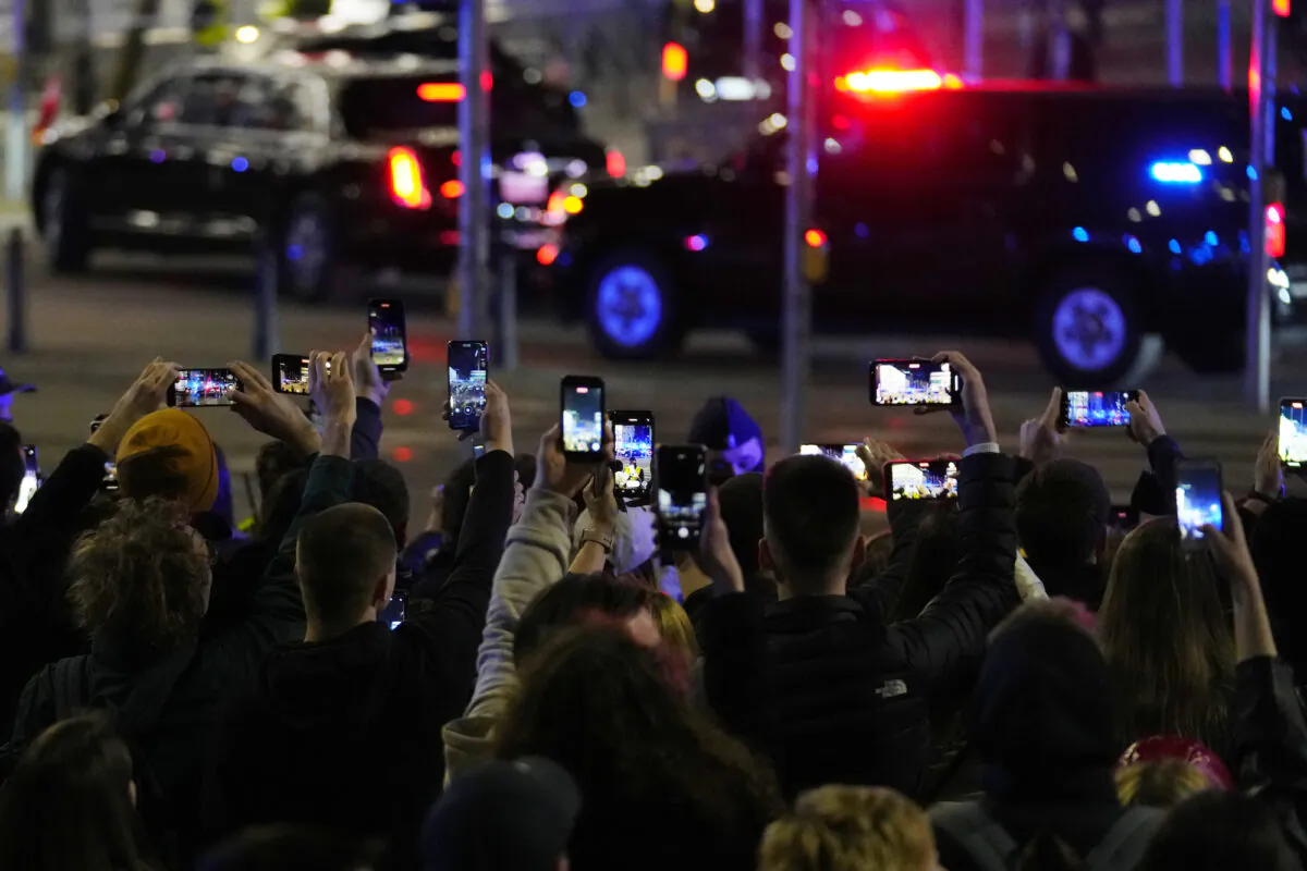 People take pictures as the motorcade with President Joe Biden arrives at the Marriot hotel in Warsaw, Poland, on March 25, 2022. (Petr David Josek/AP Photo)