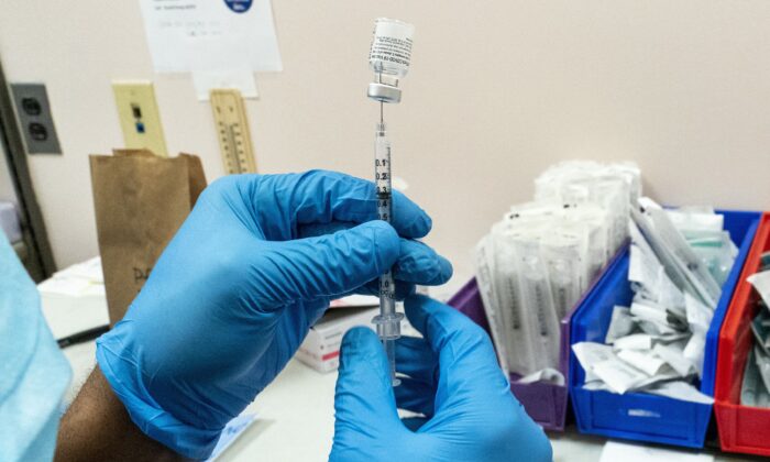 A pharmacist prepares a vaccine dose at a COVID-19 vaccination site in New York on Feb. 24, 2021. (AP Photo/Mary Altaffer)