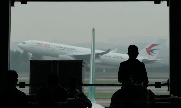 A passenger looks on as a China Eastern flight takes off from the runway of Baiyun Airport on March 25, 2022, in Guangzhou Province. China Eastern, one of China's four major airlines, said Thursday the Shanghai-based carrier and its subsidiaries have grounded a total of 223 Boeing 737-800 aircraft while they investigate possible safety hazards after the crash of its flight MU5735 on March 21. (Ng Han Guan/AP)