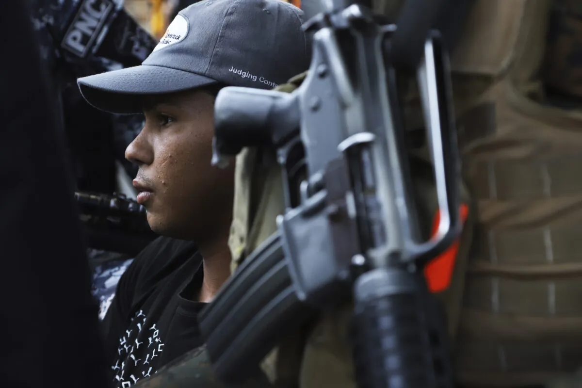A young man is detained by the police, a suspect in a homicide near a market in San Salvador, El Salvador on March 27, 2022. (Salvador Melendez/AP Photo)