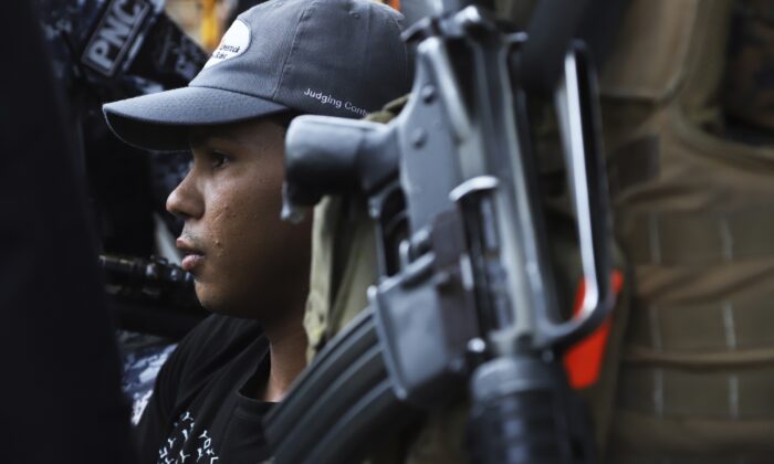 A young man is detained by the police, a suspect in a homicide near a market in San Salvador, El Salvador on March 27, 2022. (Salvador Melendez/AP Photo)