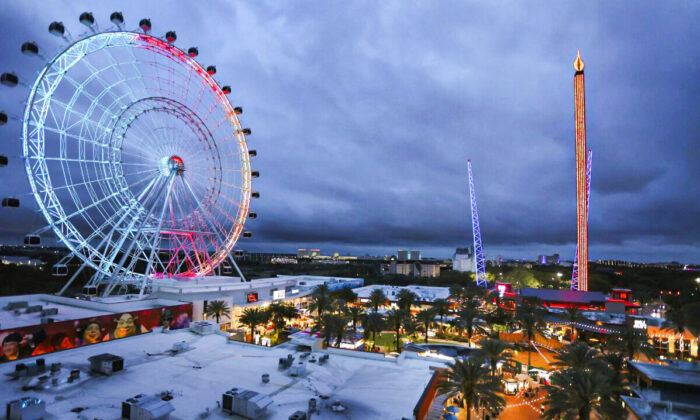 ICON Park attractions, The Wheel, left, Orlando SlingShot, middle, and Orlando FreeFall, right, are shown in Orlando, Fla. on March 24, 2022. (Stephen M. Dowell/Orlando Sentinel via AP)