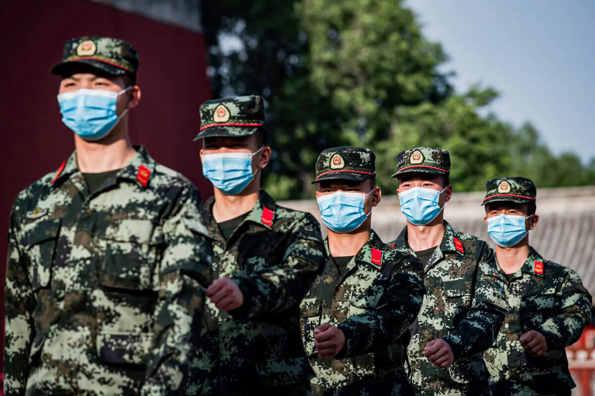 China's People's Liberation Army (PLA) soldiers march next to the entrance to the Forbidden City (L) in Beijing on May 22, 2020. (NICOLAS ASFOURI/AFP via Getty Images)