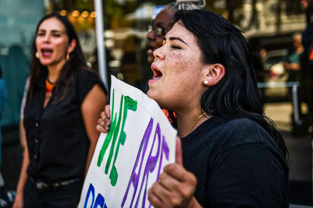 People hold placards and shout slogans as they protest outside the office of Florida State Senator Ileana Garcia in Coral Gables, Florida, on March 9, 2022. (CHANDAN KHANNA/AFP via Getty Images)