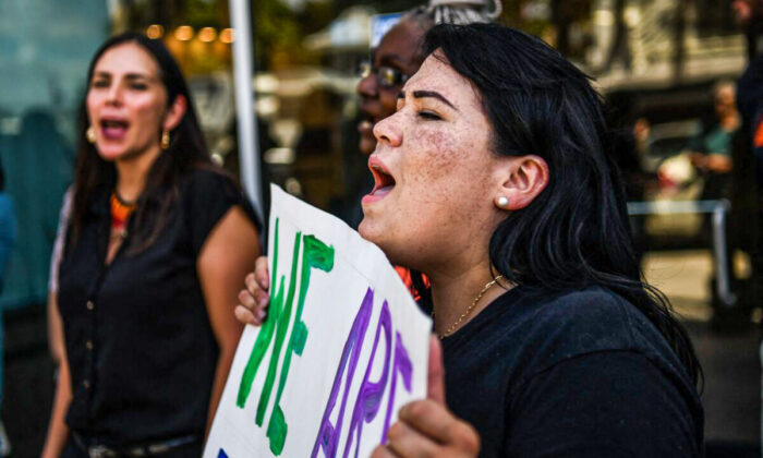 People hold placards and shout slogans as they protest outside the office of Florida State Senator Ileana Garcia in Coral Gables, Florida, on March 9, 2022. (CHANDAN KHANNA/AFP via Getty Images)