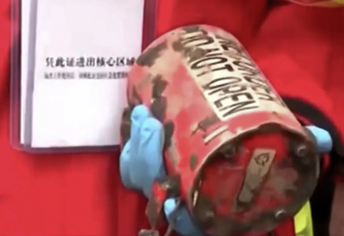 An image taken from video footage run by China's state broadcaster CCTV of a worker holding the second black box which recovered at the China Eastern flight crash site near Wuzhou city in southern China's Guangxi Province on March 23, 2022. (CCTV via Reuters/Screenshot via The Epoch Times)