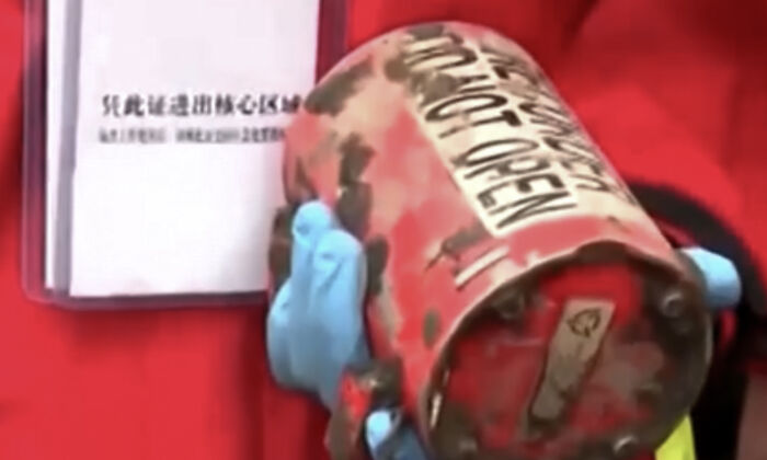 An image taken from video footage run by China's state broadcaster CCTV of a worker holding the second black box which recovered at the China Eastern flight crash site near Wuzhou city in southern China's Guangxi Province on March 23, 2022. (CCTV via Reuters/Screenshot via The Epoch Times)