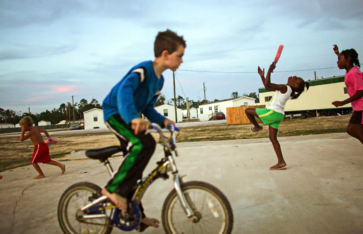 Children play in the FEMA trailer park where they live after their homes were destroyed by Hurricane Katrina May 27, 2006 in Waveland, Mississippi. The Gulf Coast has been slow to recover from the storm and the next hurricane season begins June 1st. (Mario Tama/Getty Images)