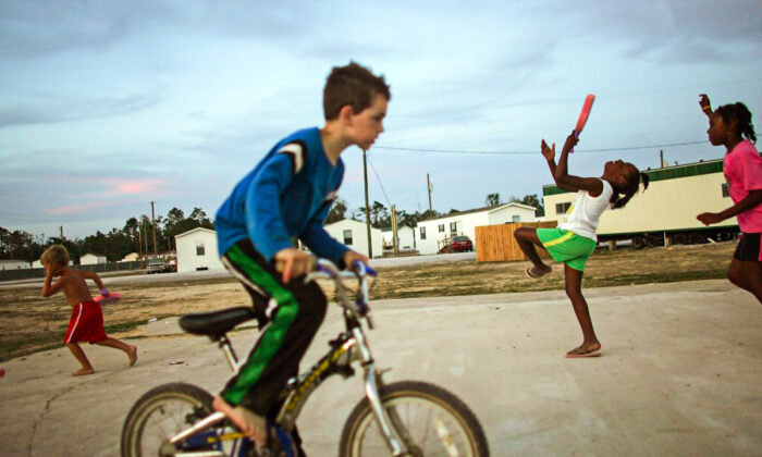 Children play in the FEMA trailer park where they live after their homes were destroyed by Hurricane Katrina May 27, 2006 in Waveland, Mississippi. The Gulf Coast has been slow to recover from the storm and the next hurricane season begins June 1st. (Mario Tama/Getty Images)