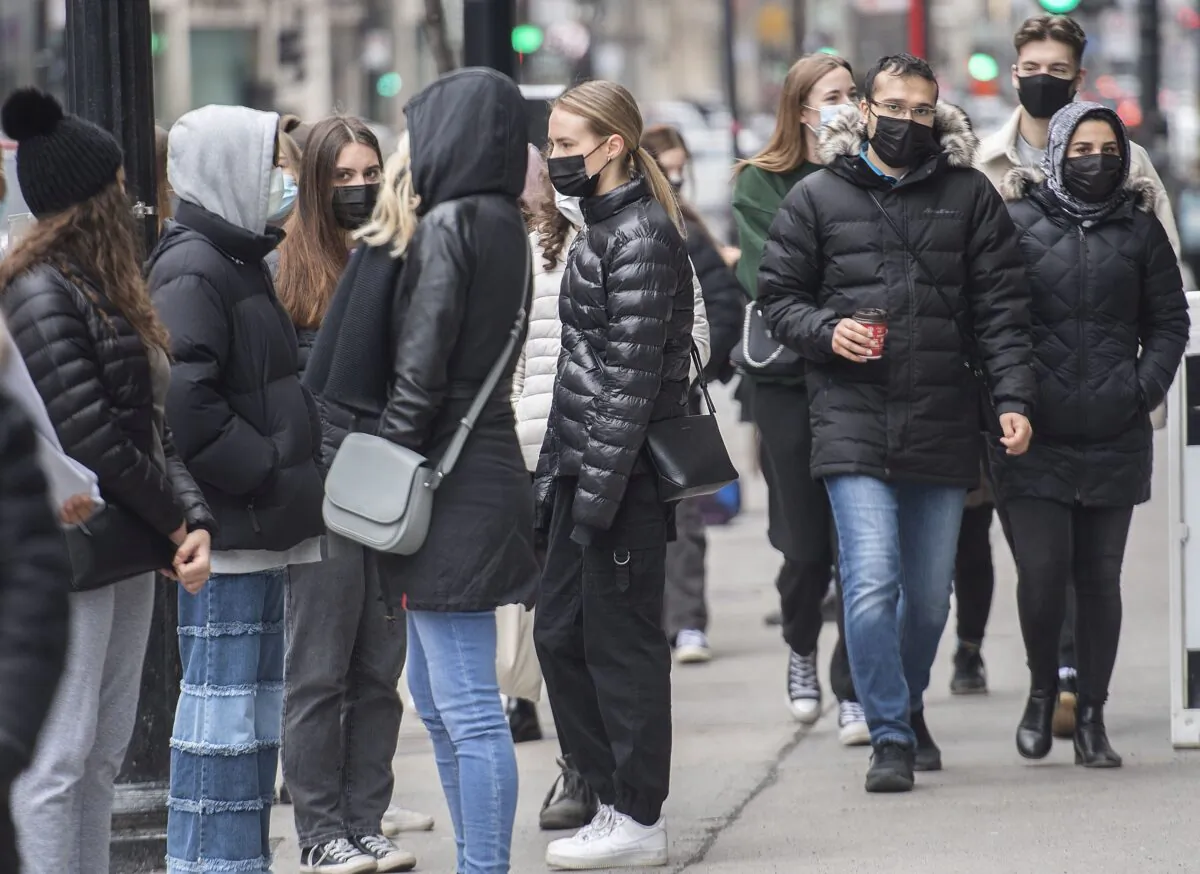 People wear masks as they walk along a street in Montreal on March 27, 2021. (The Canadian Press/Graham Hughes)