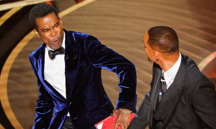 Will Smith (R) hits at Chris Rock as Rock spoke on stage during the 94th Academy Awards in Hollywood, Los Angeles, Calif., on March 27, 2022. (Brian Snyder/Reuters)