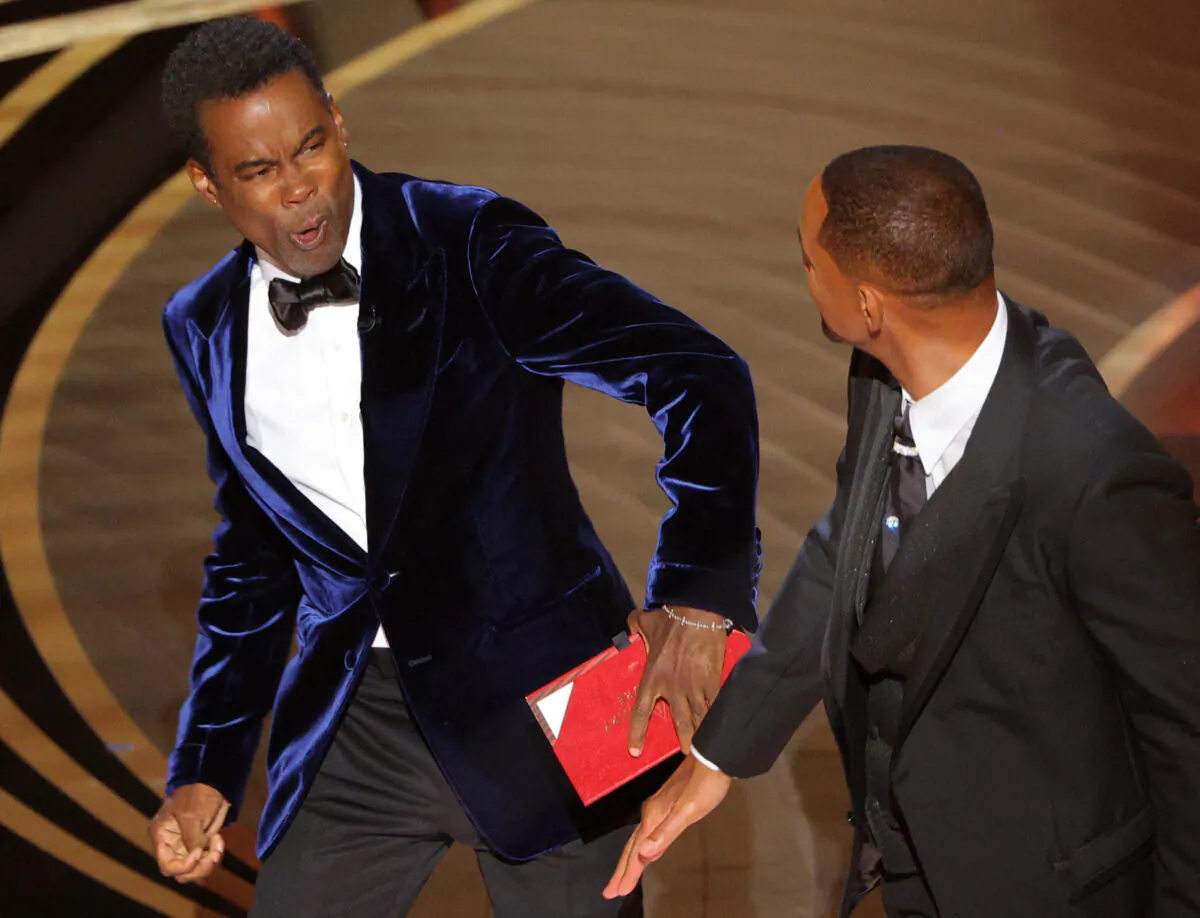 Will Smith (R) hits at Chris Rock as Rock spoke on stage during the 94th Academy Awards in Hollywood, Los Angeles, Calif., on March 27, 2022. (Brian Snyder/Reuters)