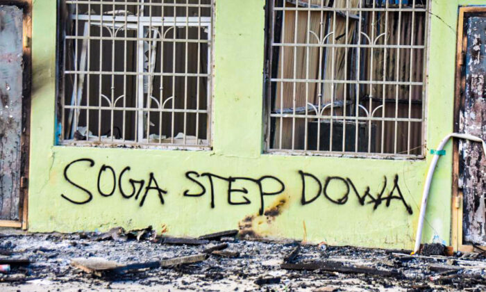 Anti-government messages adorn a burnt-out building in Honiara, Solomon Islands, on Nov. 27, 2021. (Charley Piringi/AFP via Getty Images)
